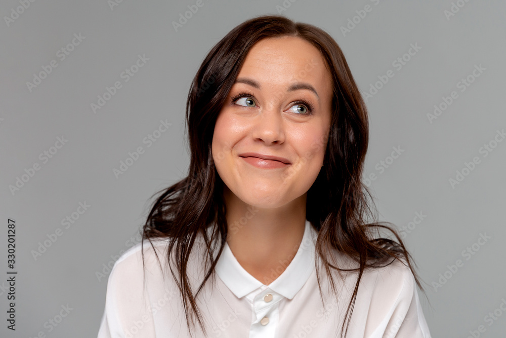Smiling young business woman in white shirt posing isolated on grey wall background studio portrait. Achievement career wealth business concept. Mock up copy space. Smiling young business woman in white shirt posing isolated on grey wall background studio portrait. Achievement career wealth business concept. Mock up copy space.