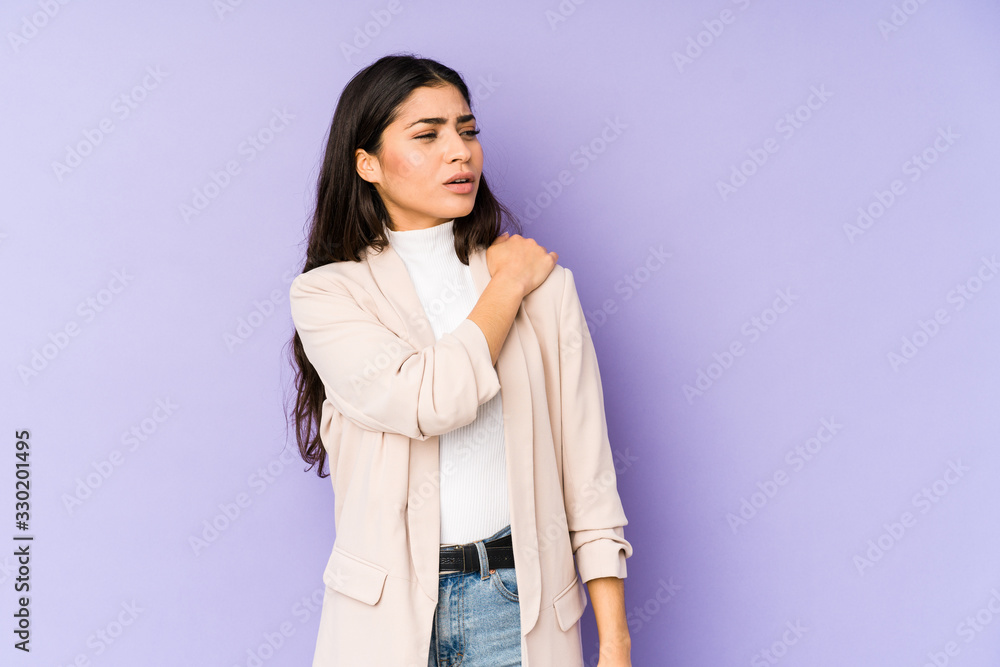 Young indian woman isolated on purple background having a shoulder pain. Young indian woman isolated on purple background having a shoulder pain.