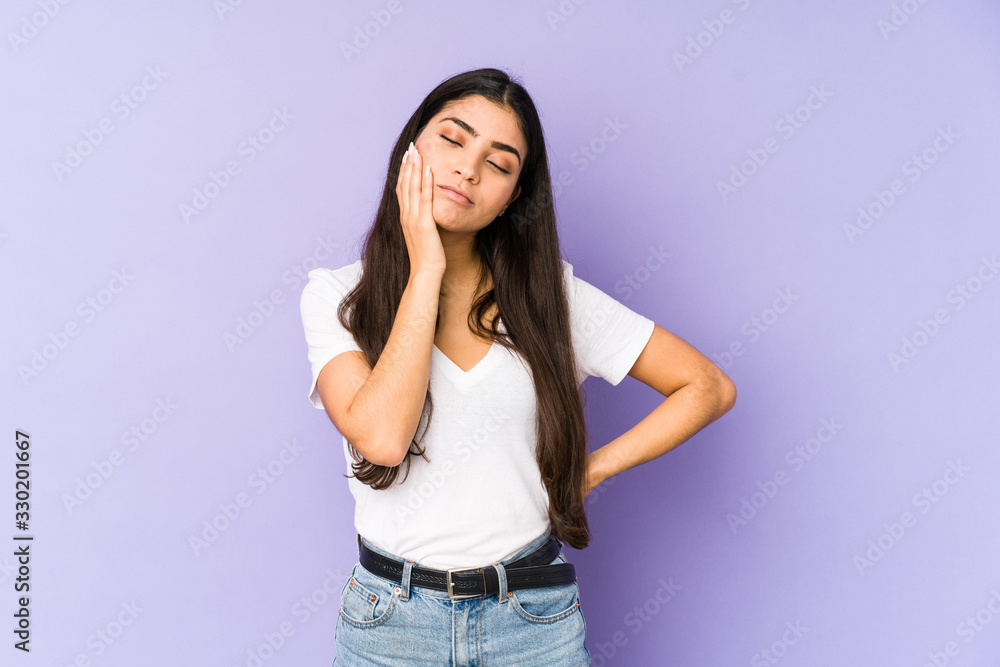 Young indian woman isolated on purple background who is bored, fatigued and need a relax day. Young indian woman isolated on purple background who is bored, fatigued and need a relax day.