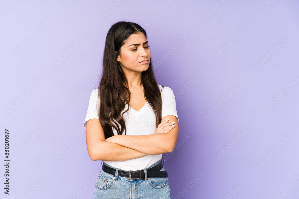 Young indian woman isolated on purple background tired of a repetitive task. Young indian woman isolated on purple background tired of a repetitive task.