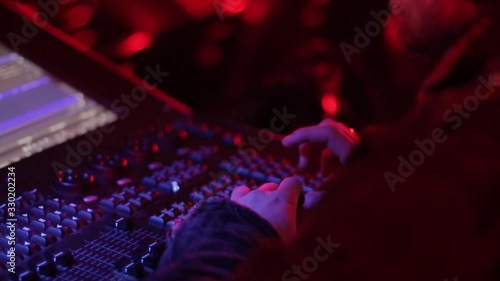 Audio mix desk at a concert. Man working on professional digital audio channel mixer in studio. Male Dj hands playing set in night club party slow motion