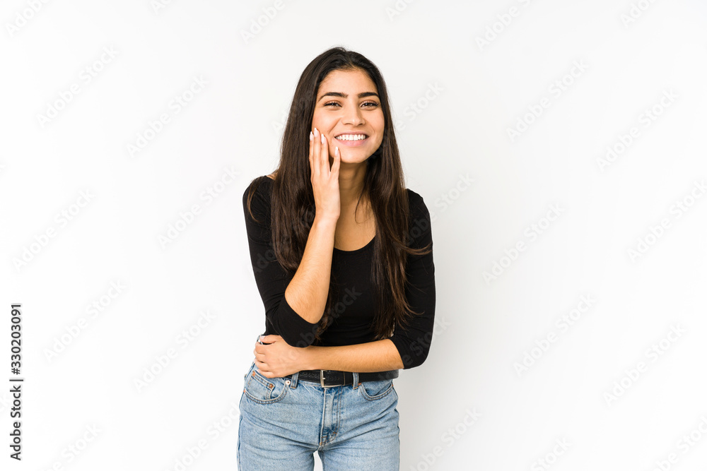 Young indian woman isolated on purple background laughs happily and has fun keeping hands on stomach. Young indian woman isolated on purple background laughs happily and has fun keeping hands on stomach.