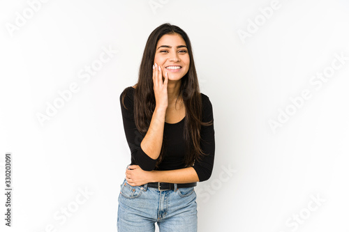 Young indian woman isolated on purple background laughs happily and has fun keeping hands on stomach.