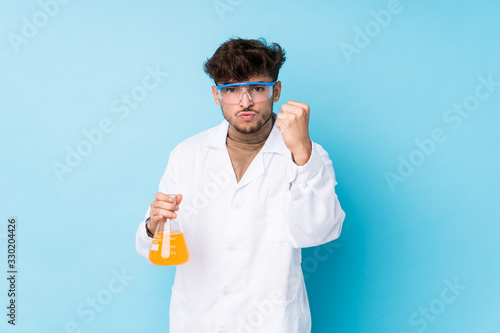 Young arab scientific man isolated showing fist to camera, aggressive facial expression.