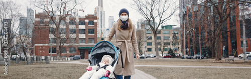 Photography Caucasian mother in surgical mask walking with baby outdoor in Toronto