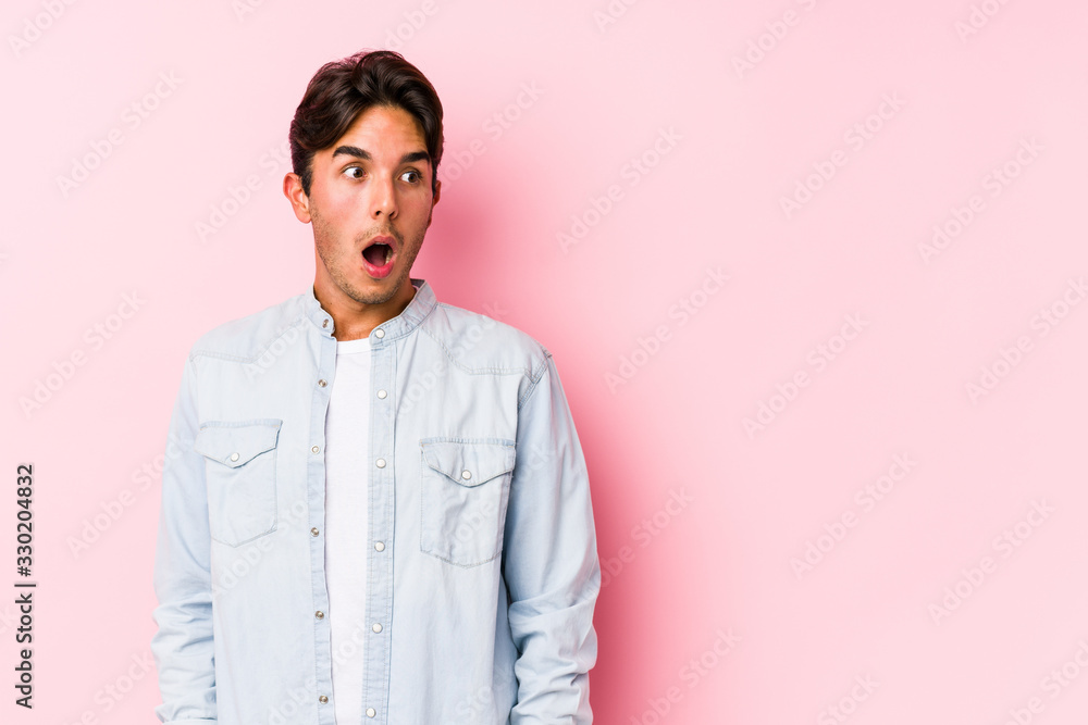Young caucasian man posing in a pink background isolated being shocked because of something she has seen. Young caucasian man posing in a pink background isolated being shocked because of something she has seen.