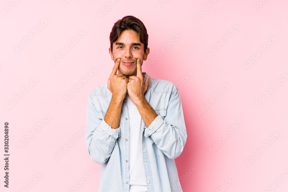 Young caucasian man posing in a pink background isolated doubting between two options. Young caucasian man posing in a pink background isolated doubting between two options.