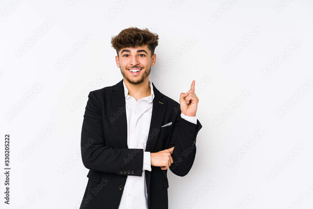Young arabian business man isolated smiling cheerfully pointing with forefinger away. Young arabian business man isolated smiling cheerfully pointing with forefinger away.