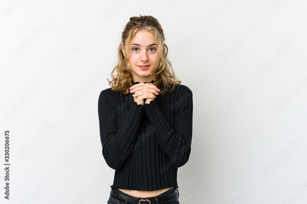 Young caucasian woman on white backrgound praying for luck, amazed and opening mouth looking to front. Young caucasian woman on white backrgound praying for luck, amazed and opening mouth looking to front.