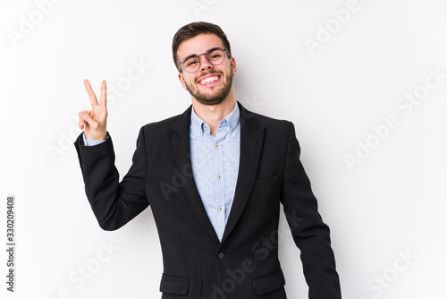 Young caucasian business man posing in a white background isolated Young caucasian business man joyful and carefree showing a peace symbol with fingers.