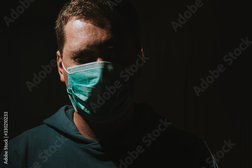 man wearing mask for protection from corona viruse covid-19 on dark background