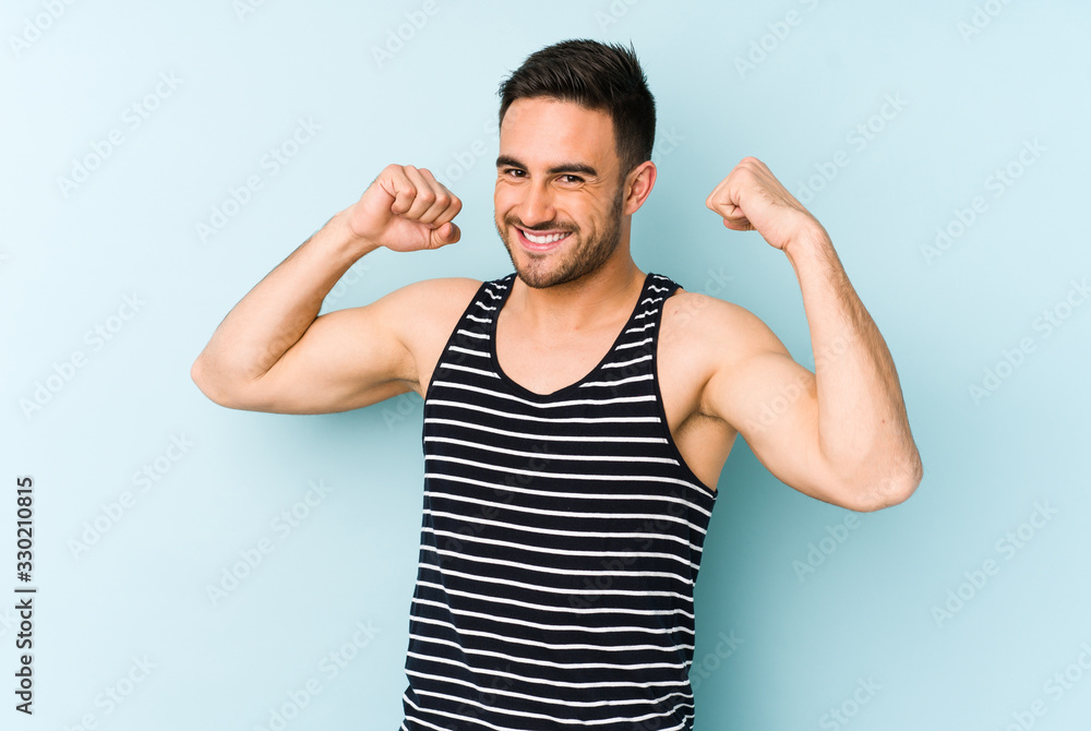Young caucasian man isolated on blue background celebrating a special day, jumps and raise arms with energy. Young caucasian man isolated on blue background celebrating a special day, jumps and raise arms with energy.