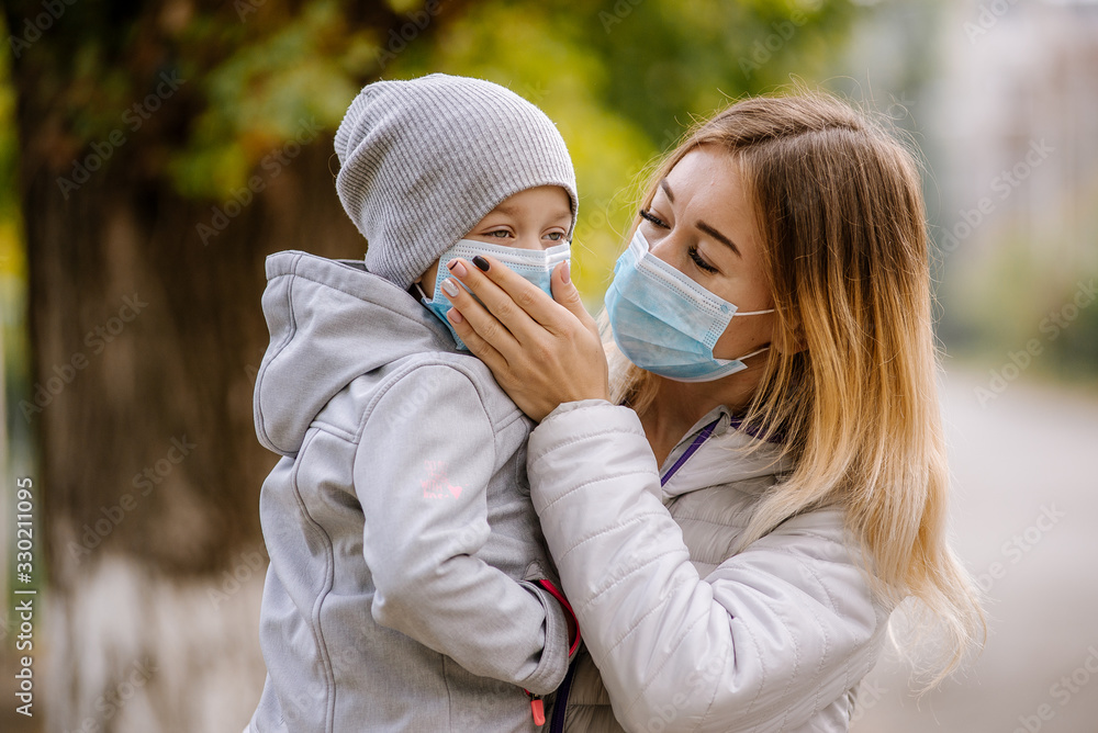 Girl with a child stands on the road in a protective medical mask in Italy. Coronovirus in Europe Girl with a child stands on the road in a protective medical mask in Italy. Coronovirus in Europe