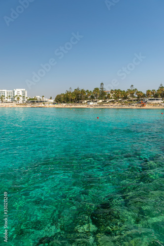 CYPRUS, NISSI BEACH - MAY 12/2018: Tourists relax and swim on one of the most popular beaches on the island. © Sergej Ljashenko