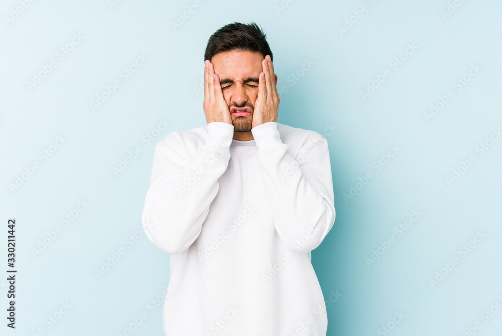 Young caucasian man isolated on blue background whining and crying disconsolately. Young caucasian man isolated on blue background whining and crying disconsolately.