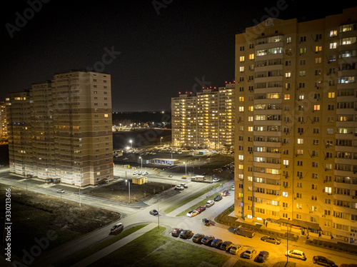 residential area night shot. light in the windows. parked cars