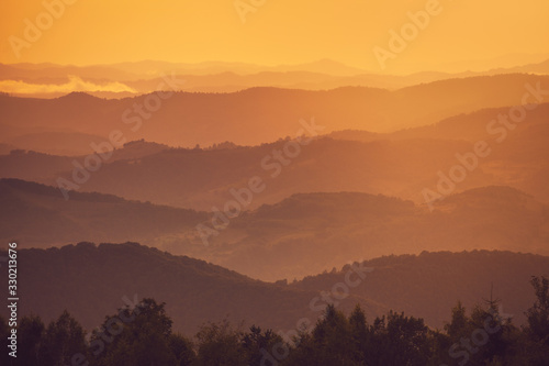 Mountain silhouettes stacked at sunset  from near to distant