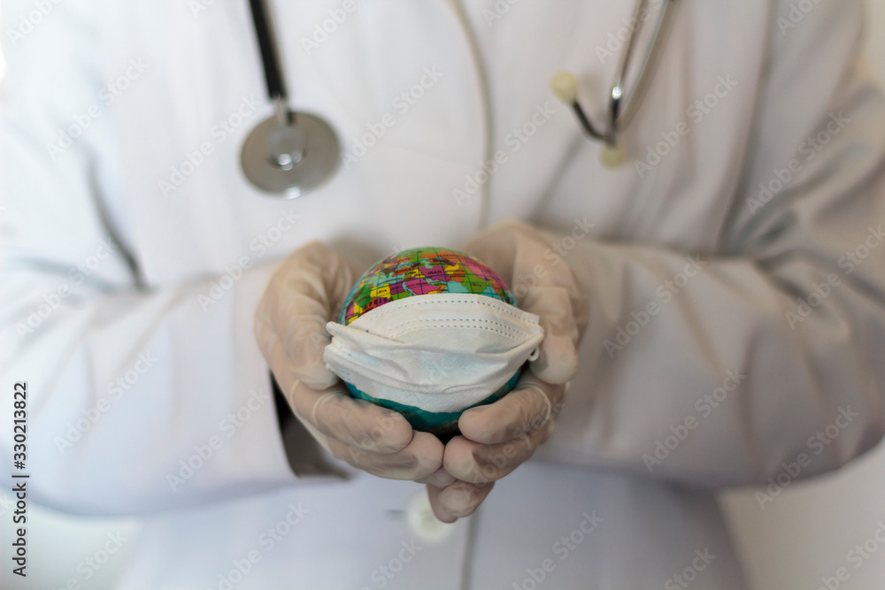 Doctor with gloves holding world globe with face mask. Pandemic concept, Coronavirus, Covid-19, international emergency, global quarantine Doctor with gloves holding world globe with face mask. Pandemic concept, Coronavirus, Covid-19, international emergency, global quarantine