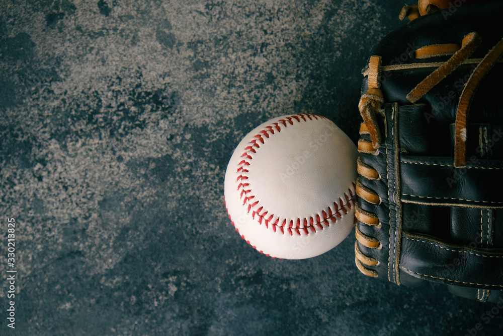 Baseball glove and ball flat lay on grunge texture backdrop, copy space on background for sport.  Isolated sports equipment.