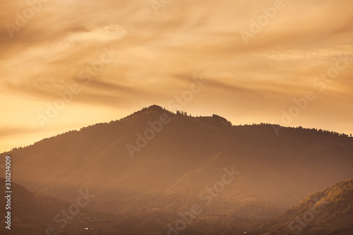 Simple mountain silhouette landscape at sunset  spruce trees on the peak