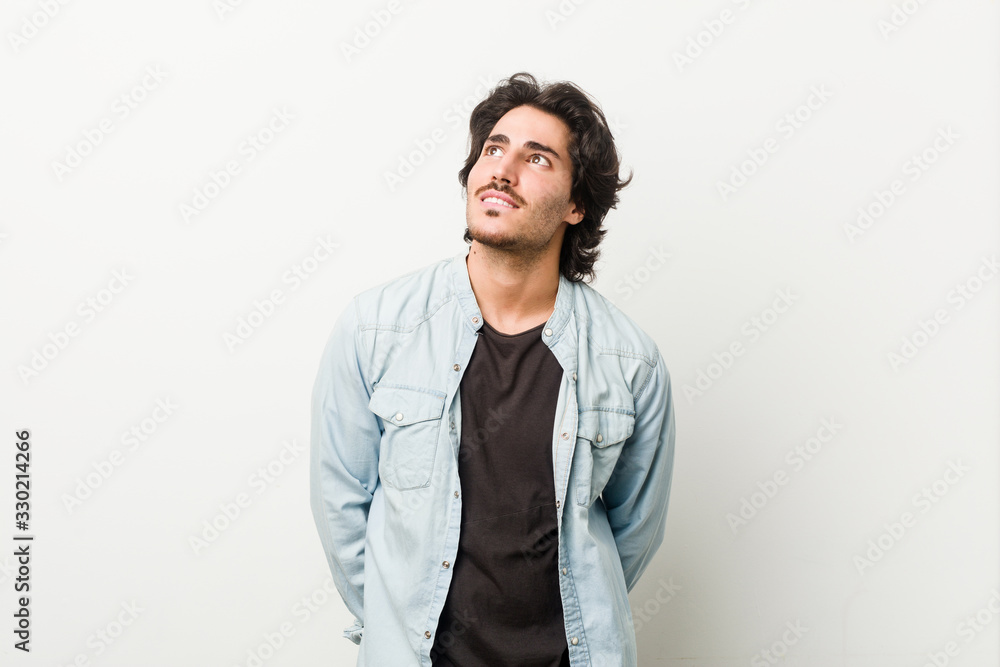 Young handsome man against a white background dreaming of achieving goals and purposes Young handsome man against a white background dreaming of achieving goals and purposes
