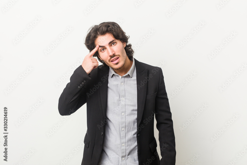 Young business man against a white background showing a disappointment gesture with forefinger. Young business man against a white background showing a disappointment gesture with forefinger.