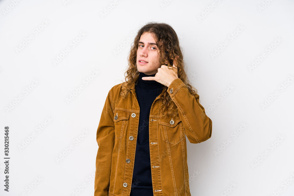 Long hair man posing isolated showing a mobile phone call gesture with fingers. Long hair man posing isolated showing a mobile phone call gesture with fingers.
