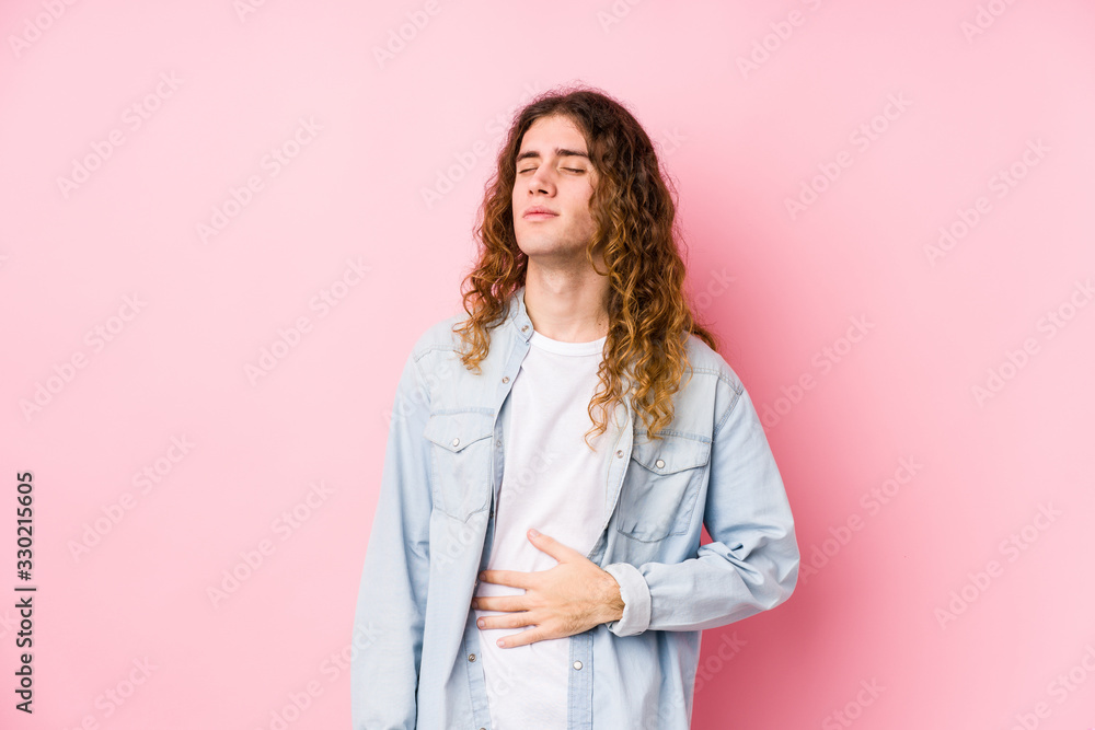 Long hair man posing isolated touches tummy, smiles gently, eating and satisfaction concept. Long hair man posing isolated touches tummy, smiles gently, eating and satisfaction concept.