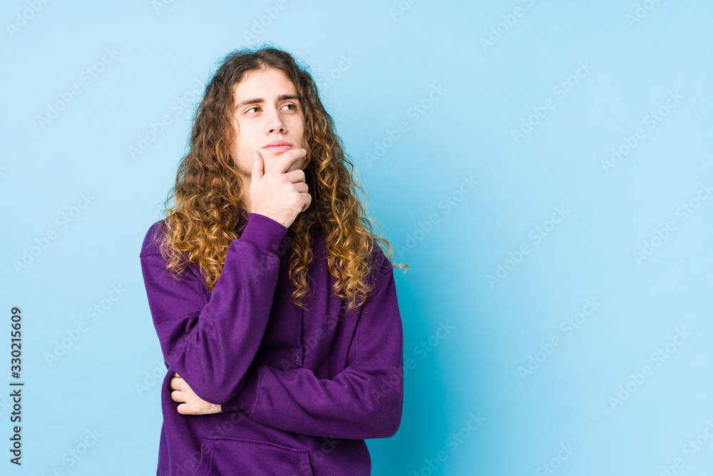 Long hair man posing isolated looking sideways with doubtful and skeptical expression. Long hair man posing isolated looking sideways with doubtful and skeptical expression.