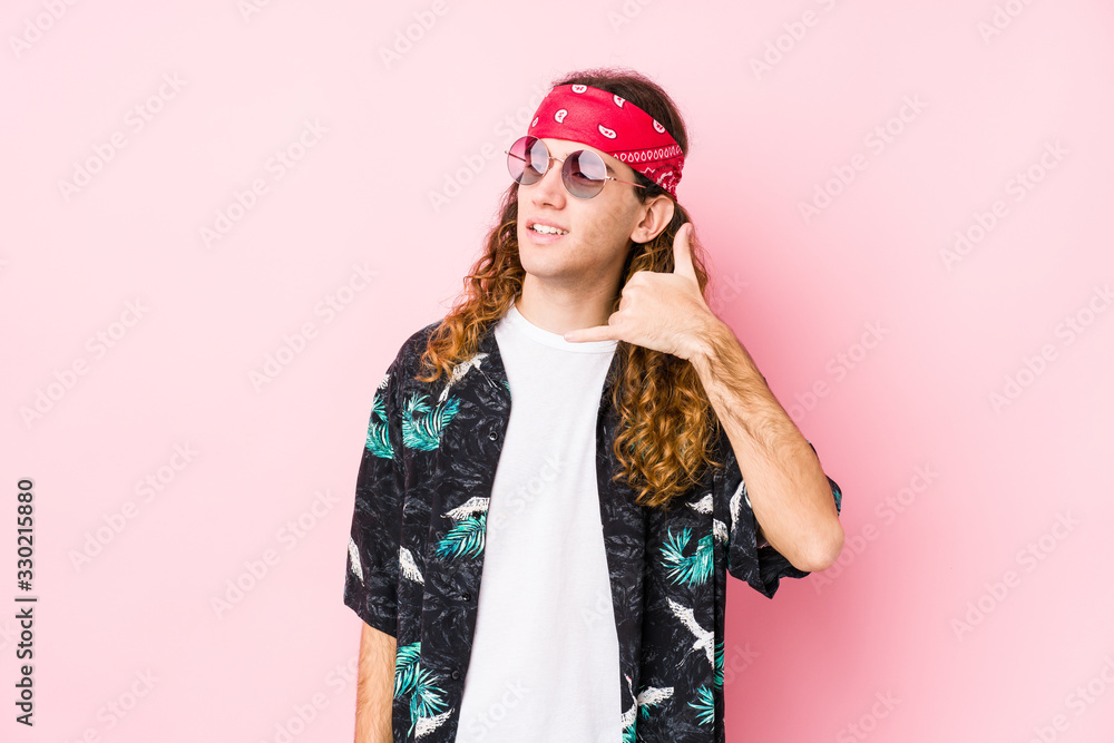 Young hippie caucasian man isolated showing a mobile phone call gesture with fingers.