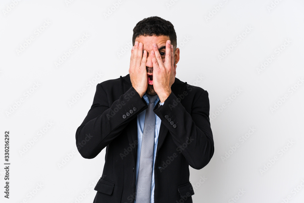 Young latin business woman against a white background isolated blink through fingers frightened and nervous. Young latin business woman against a white background isolated blink through fingers frightened and nervous.