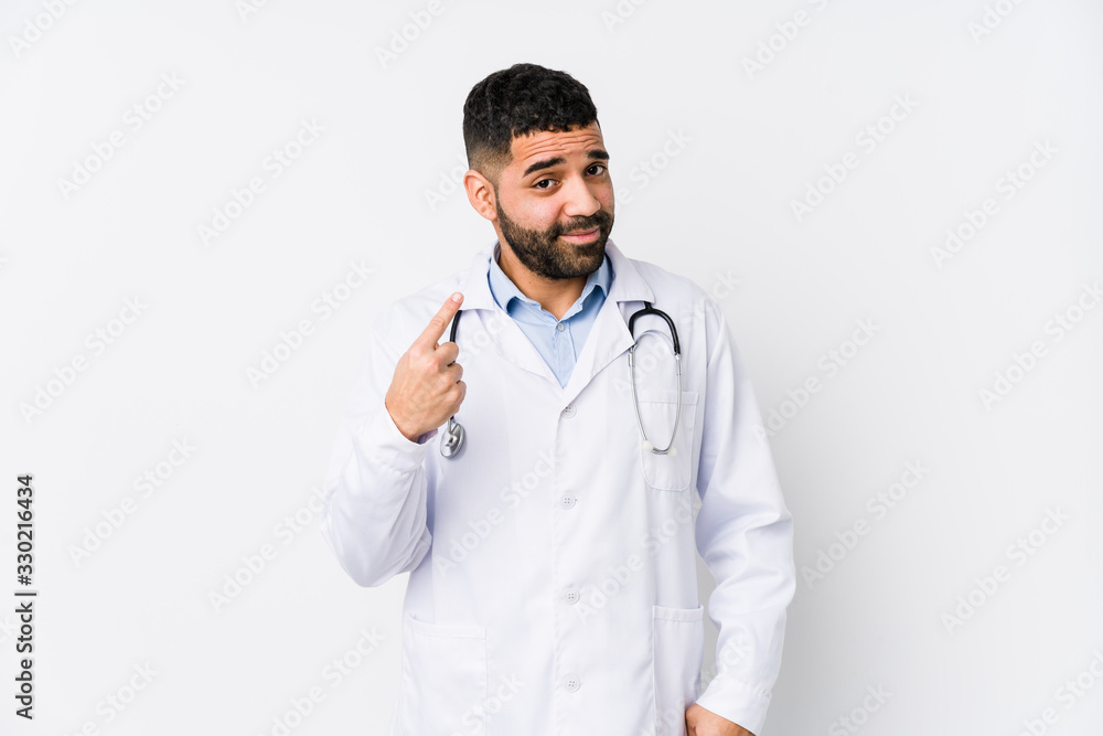 Young arabian doctor man isolated pointing with finger at you as if inviting come closer. Young arabian doctor man isolated pointing with finger at you as if inviting come closer.