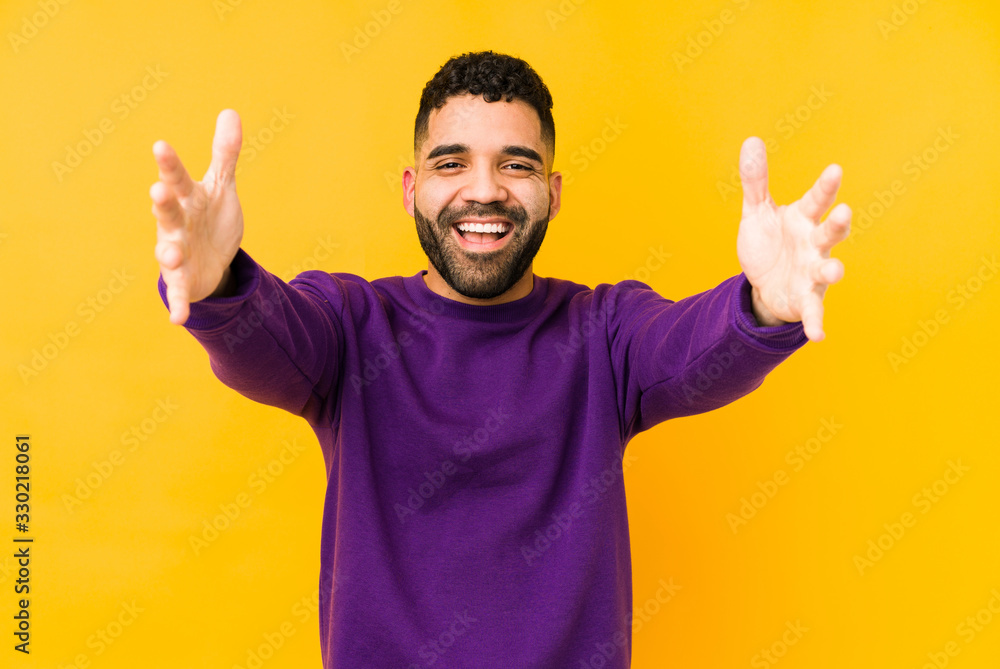 Young mixed race arabic man isolated feels confident giving a hug to the camera. Young mixed race arabic man isolated feels confident giving a hug to the camera.