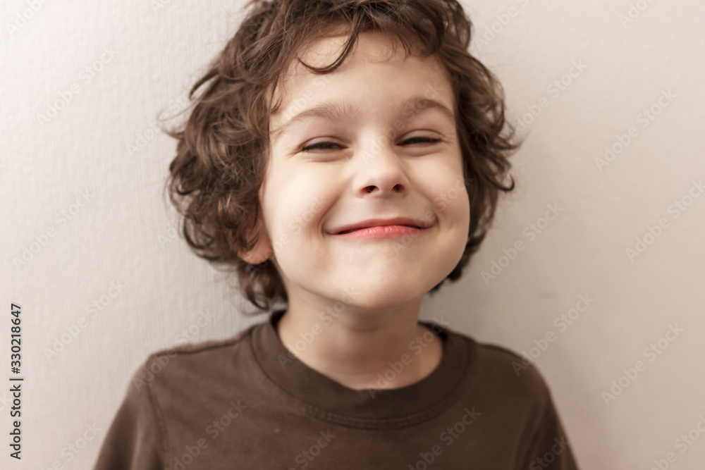 very pleased curly-haired boy with closed eyes in pleasure on white background very pleased curly-haired boy with closed eyes in pleasure on white background
