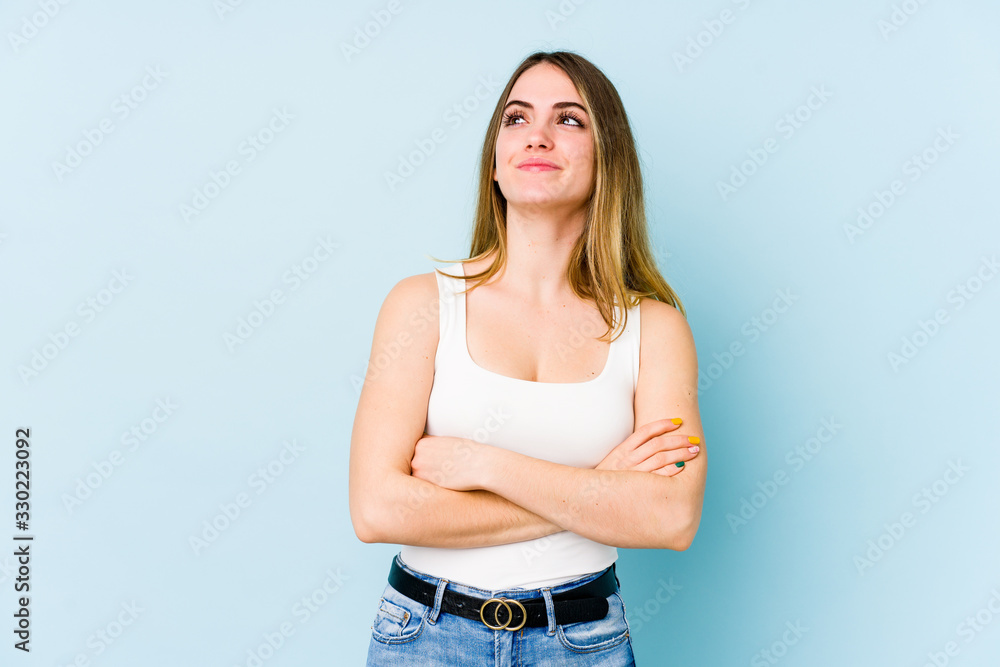 Young caucasian woman isolated on blue background dreaming of achieving goals and purposes Young caucasian woman isolated on blue background dreaming of achieving goals and purposes