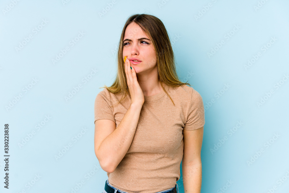 Young caucasian woman isolated on blue background having a strong teeth pain, molar ache. Young caucasian woman isolated on blue background having a strong teeth pain, molar ache.