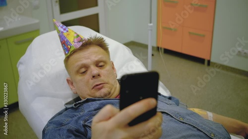a man in a denim suit and a festive cap takes a selfie on the phone