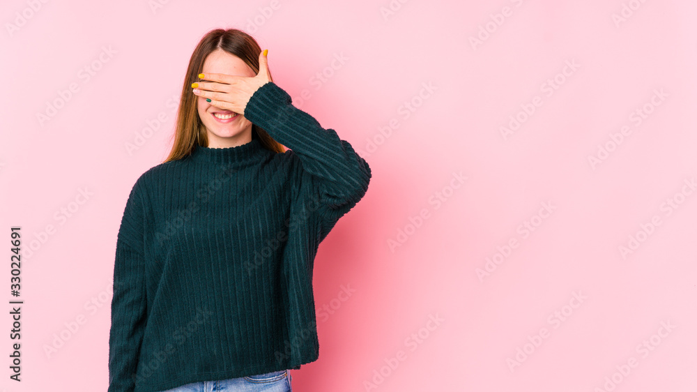Obraz premium Young caucasian woman isolated on pink background covers eyes with hands, smiles broadly waiting for a surprise.
