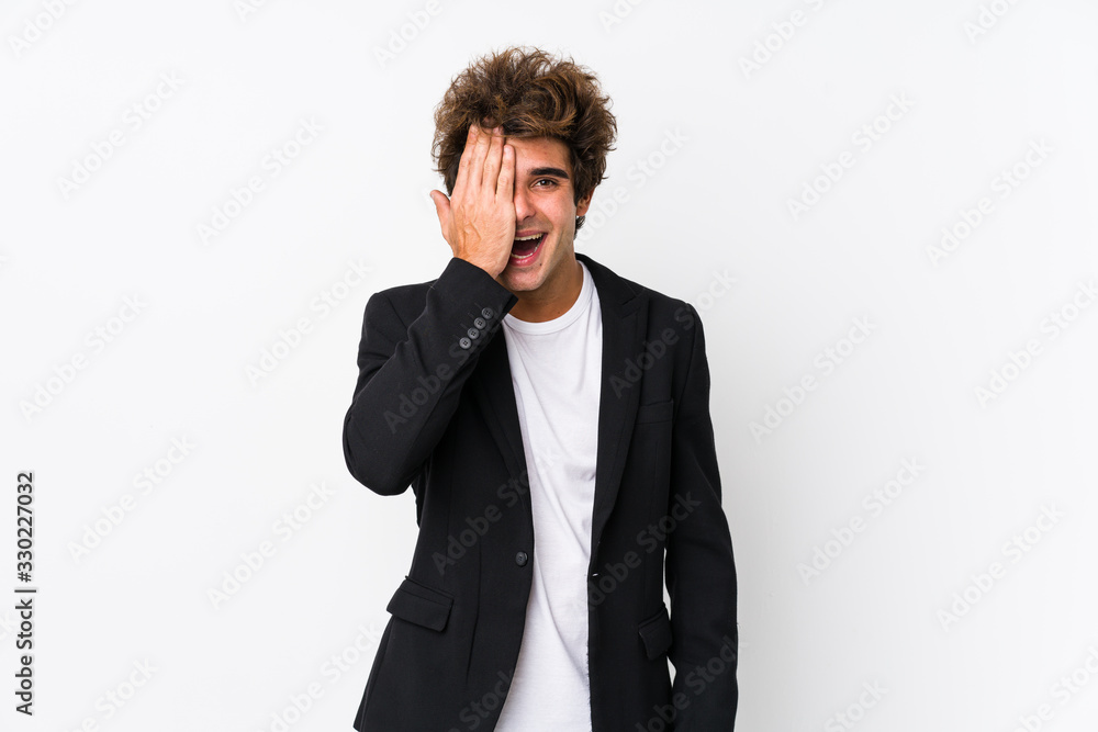Young caucasian business man against a white background isolated having fun covering half of face with palm. Young caucasian business man against a white background isolated having fun covering half of face with palm.