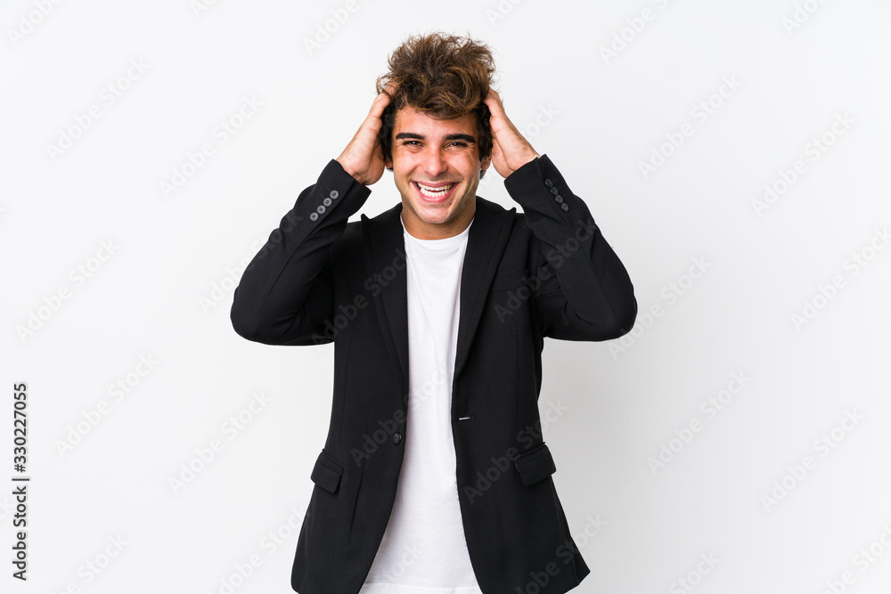 Young caucasian business man against a white background isolated laughs joyfully keeping hands on head. Happiness concept. Young caucasian business man against a white background isolated laughs joyfully keeping hands on head. Happiness concept.
