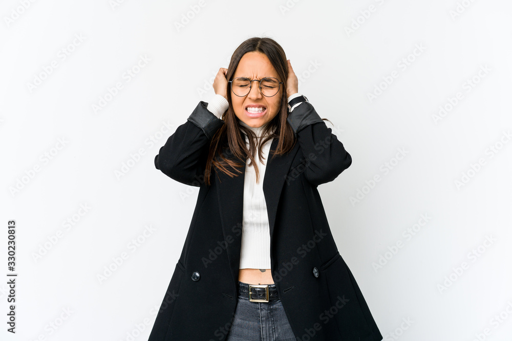 Young mixed race business woman isolated on white background covering ears with hands. Young mixed race business woman isolated on white background covering ears with hands.