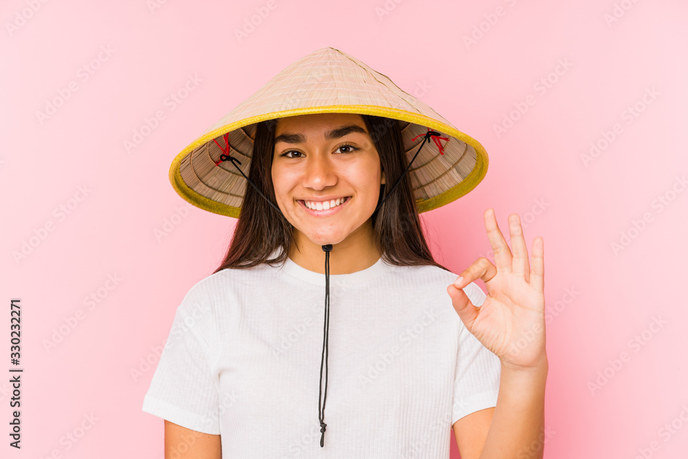 Young asian woman wearing a vietnamese hat isolated Young asian woman wearing a vietnamin hatcheerful and confident showing ok gesture. Young asian woman wearing a vietnamese hat isolated Young asian woman wearing a vietnamin hatcheerful and confident showing ok gesture.