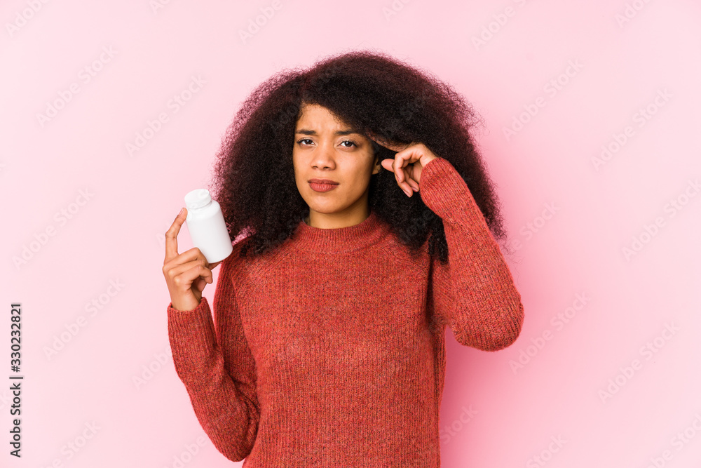 Young afro woman holding a vitamins isolated Young afro woman holding a vitaminsshowing a disappointment gesture with forefinger. Young afro woman holding a vitamins isolated Young afro woman holding a vitaminsshowing a disappointment gesture with forefinger.