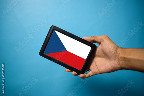 Man holding Smartphone with Flag of Czech. Czech Flag on Mobile Screen isolated On Blue Background