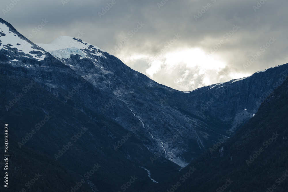 montaña con nieve y nubes al atardecer