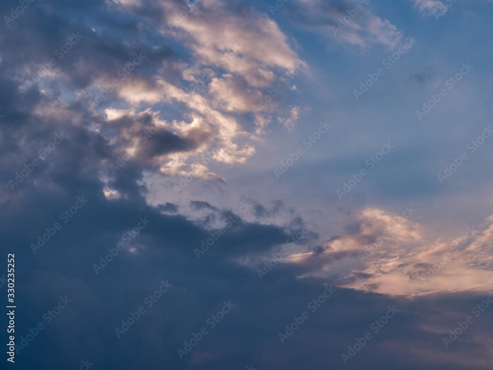 Beautiful sky with clouds at sunset. Soft light from the setting sun. Summer day