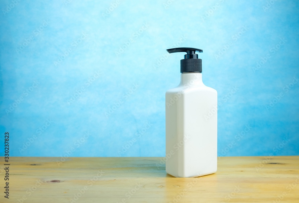 white hand sanitizer over blue background. Conceptual image of staying safe and clean. white hand sanitizer over blue background. Conceptual image of staying safe and clean.
