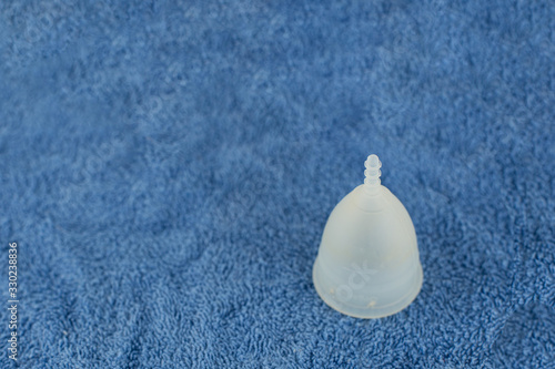 Eco friendly menstrual cup on a blue towel.