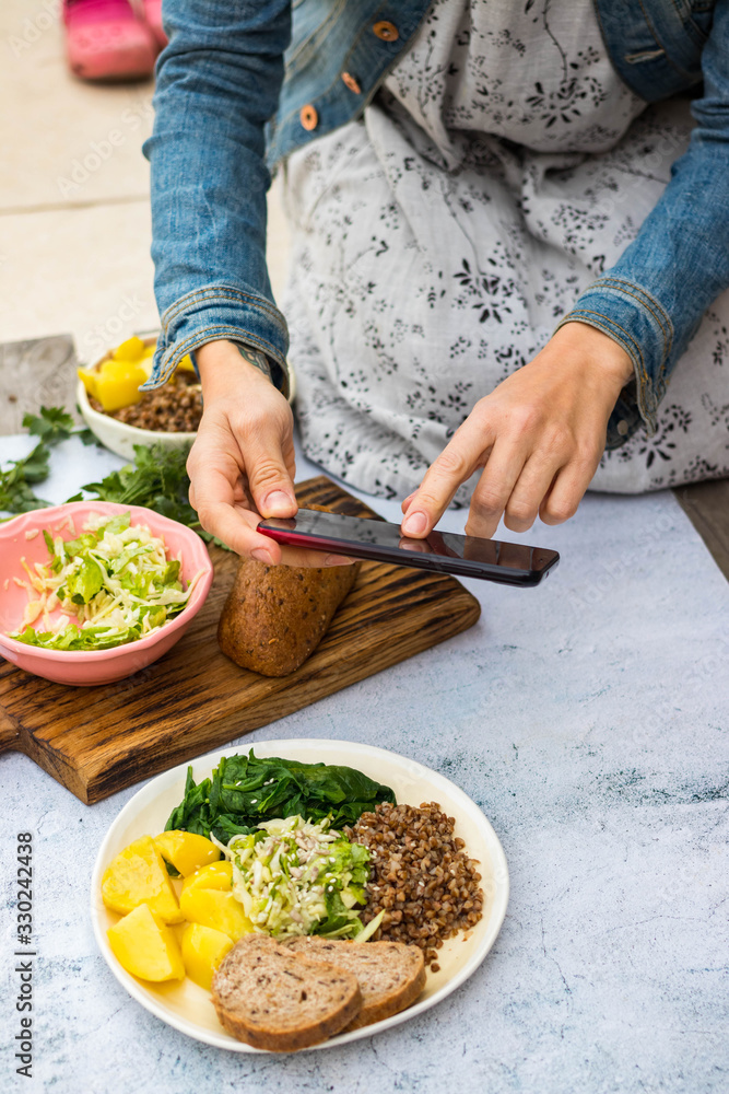 Φωτογραφία Woman take picture of food with phone at kitchen or summer cafe