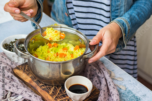 Indian basmati biryani pilaf colorful rice in woman hands with vegetables. Vegan, vegetarian healthy food.